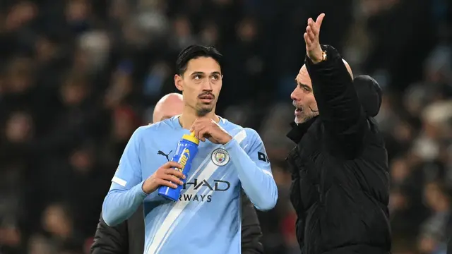 Manajer Manchester City, Pep Guardiola (kanan), berbicara dengan pemainnya, Tijjani Reijnders,