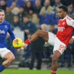 Pemain Arsenal, Jurrien Timber berebut bola dengan pemain Everton Jack Grealish dalam laga Liga Inggris,