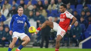 Pemain Arsenal, Jurrien Timber berebut bola dengan pemain Everton Jack Grealish dalam laga Liga Inggris,